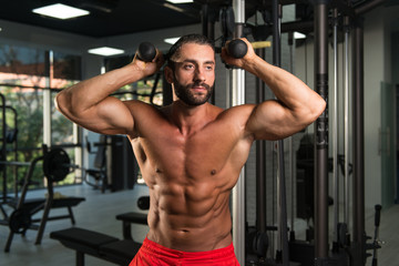 Fototapeta na wymiar Hispanic Man Exercising Triceps In The Gym