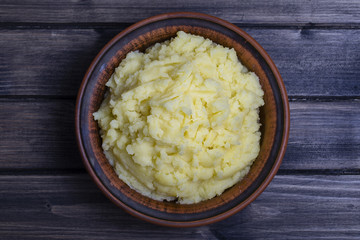 Mashed potatoes in a plate on the wooden table