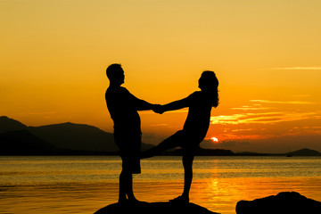 Romantic of couple love standing on the stone looking sunset at