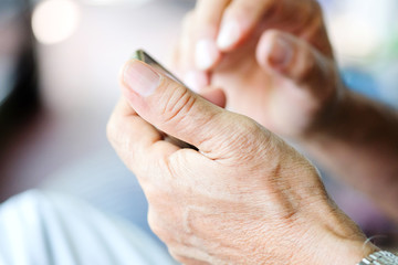Obraz na płótnie Canvas Close up of older man checking his phone background