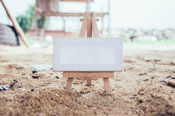 conceptual image white canvas and wooden easel over blurred background