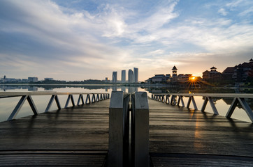 beautiful morning at lakeside. building reflection on the lake surface, soft and dramatic cloud with colorful on the sky. wooden jetty and soft look on the lake surface.