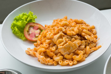 Macaroni and tomato sauce with chicken meat decorated with scall