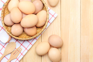 Fresh egg in the basket weaving over wooden table background, Top view with copy space and text.