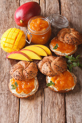 Breakfast: Sandwiches with sweet mango jam and butter close-up. vertical