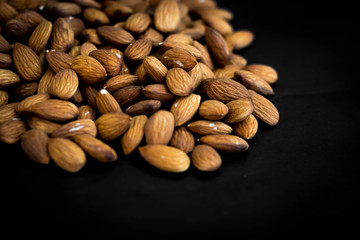 close up almonds nuts on black background