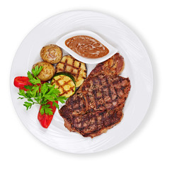 Grilled steak, baked potatoes and vegetables on white plate isolated on white background.