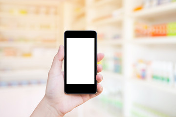 Pharmacy store with female holding mobile phone