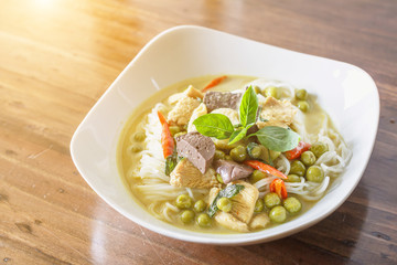 Green curry chicken with thai Rice Noodles and sunlight. Green curry thai food background for design.