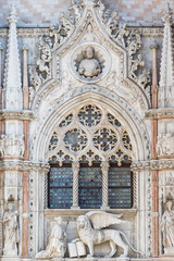 Fototapeta na wymiar Architectural detail of Basilica of Saint Mark (Venice, Italy). Vertically. Closeup view of sculpture of Doge and Venetian lion.