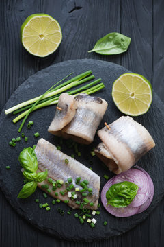 Herring fillet with red and green onion, lime and basil, closeup