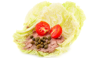 Meat pate with capers and tomato on lettuce