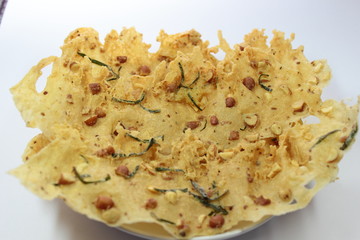 several piles of snacks made from flour and peanuts, crispy and savory like a cracker on a white...