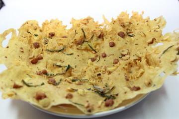 several piles of snacks made from flour and peanuts, crispy and savory like a cracker on a white...