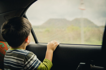 Little boy looking through window