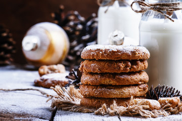 Christmas cookies and warm milk in bottles, rustic style, vintag