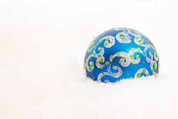 Christmas ball on a blue snowy background.