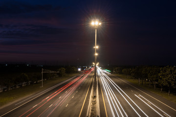 Fototapeta na wymiar Speed Traffic at light trails on motorway highway at night,backg