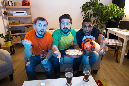 Image of funne friends watching football game on TV and waiting for exciting and amazing moments from foolball players.