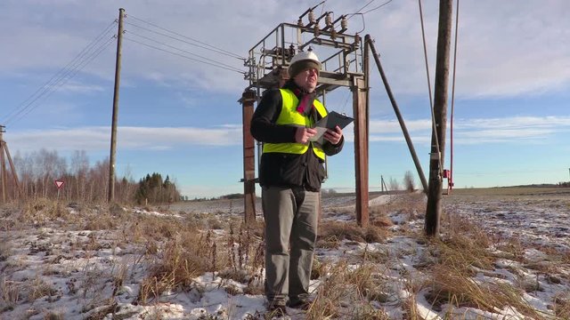 Electrician engineer talking near power lines and transformer
