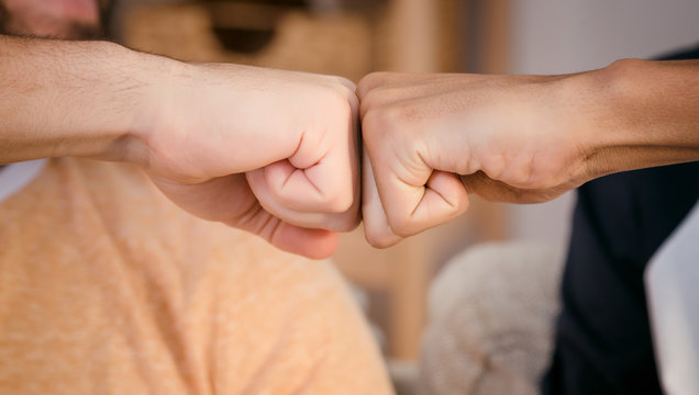 Closeup picture of two best friends men's wrists demonstrating unity and team work between two peoples from different countries.