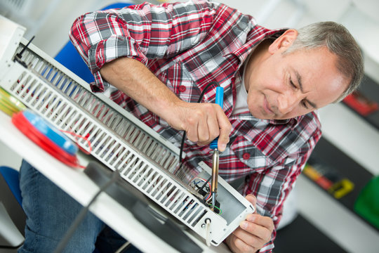 middle-age man plumber fixing radiator