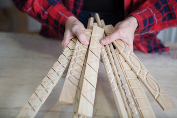 Close up carpenter's hands with woodcarving. Carpentry concept.

