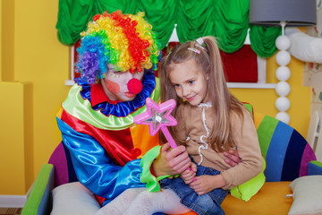 Girl playing with cheerful clown