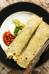 Top view of homemade chicken fajitas with vegetables, lime and salsa sauce on wooden background. Bali, Indonesia.