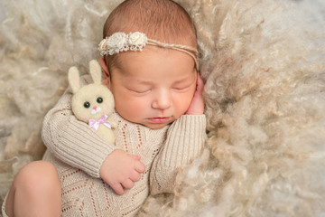 portrait of sweet sleeping newborn girl with toy hare