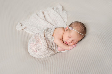 lovely sleeping infant wrapped in gray warm diaper