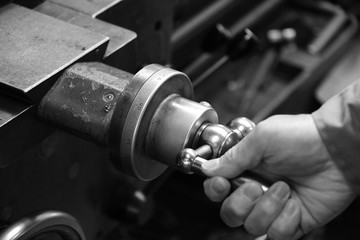 Craftsman using the Obsolete lathe. Black-and-white photo.