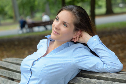 Lady leaning back on park bench