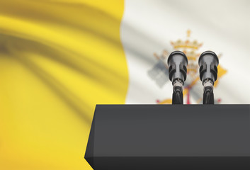 Pulpit and two microphones with a national flag on background - Vatican City State
