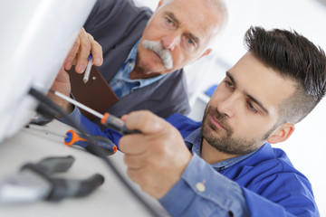 vocational student learns air conditioning repair from an experienced instructor