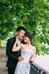Chinese Wedding couple standing in the alley of green leaves
