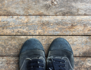 Black sneakers from an aerial view on wooden floors. Top view.