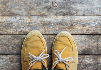 yellow sneakers from an aerial view on wooden floors. Top view.
