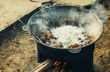 the meat is cooked in a cauldron on the street