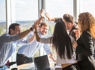 Business people showing team work and giving five after signing agreement or contract between companies, enterprises in office interior. Agreement or contract concept.