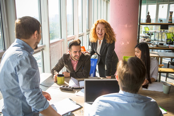 Happy business collegue communicating about business projects or strategies while working round table in board room in office. Agreement or contract concept.