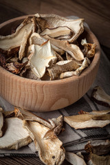 Dried mushrooms in wooden bowl.