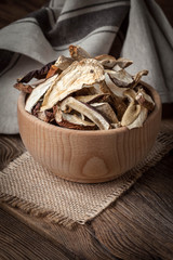 Dried mushrooms in wooden bowl.