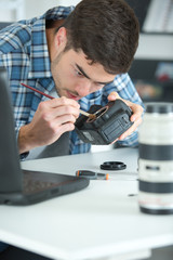 photographer cleaning lens of his digital camera