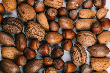 Nuts set almonds, hazelnuts, peanuts, Brazil nuts, walnuts on white texture background