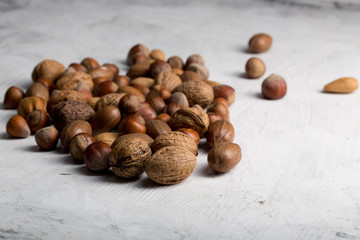Nuts set almonds, hazelnuts, peanuts, Brazil nuts, walnuts on white texture background