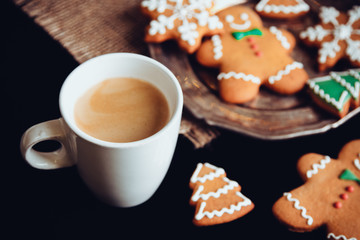 Beautiful Christmas background cookies and cap of coffee on dark background