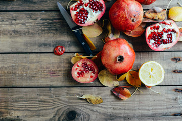 Ripe pomegranate fruit on wooden vintage background. Red juice p