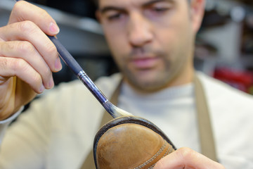 Cobbler repairing sole of shoe