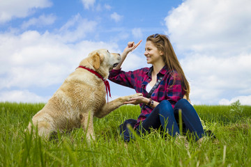 Labrador Retriever Hund gibt junger Frau das Pfötchen